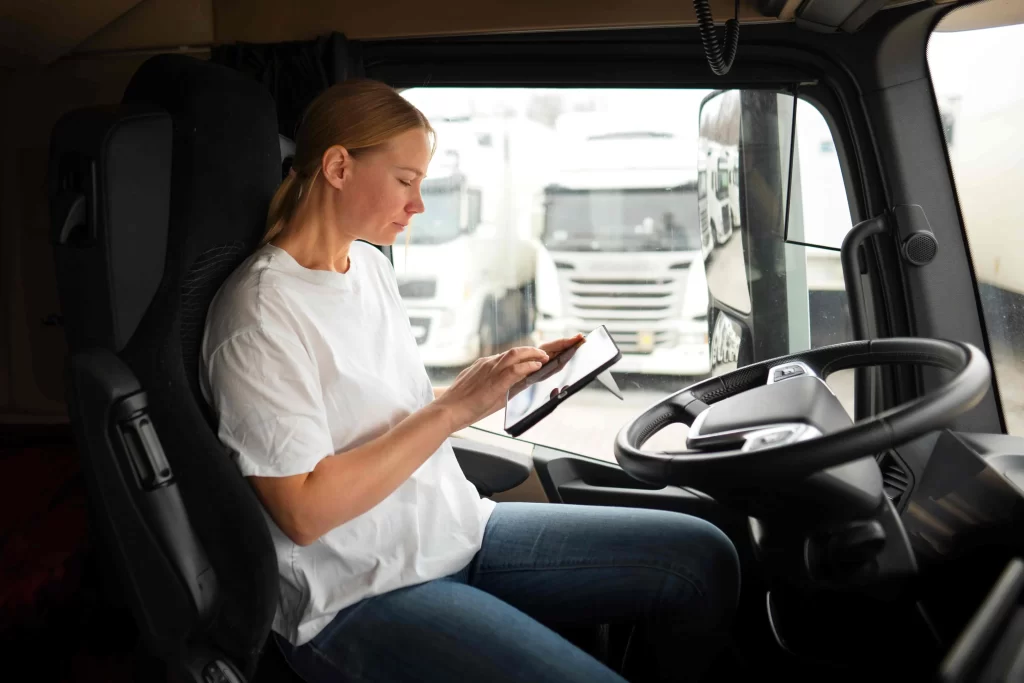 Fleet manager seating on the driver's seat monitoring fleet tracking performance, vehicle activity, and safety reports.