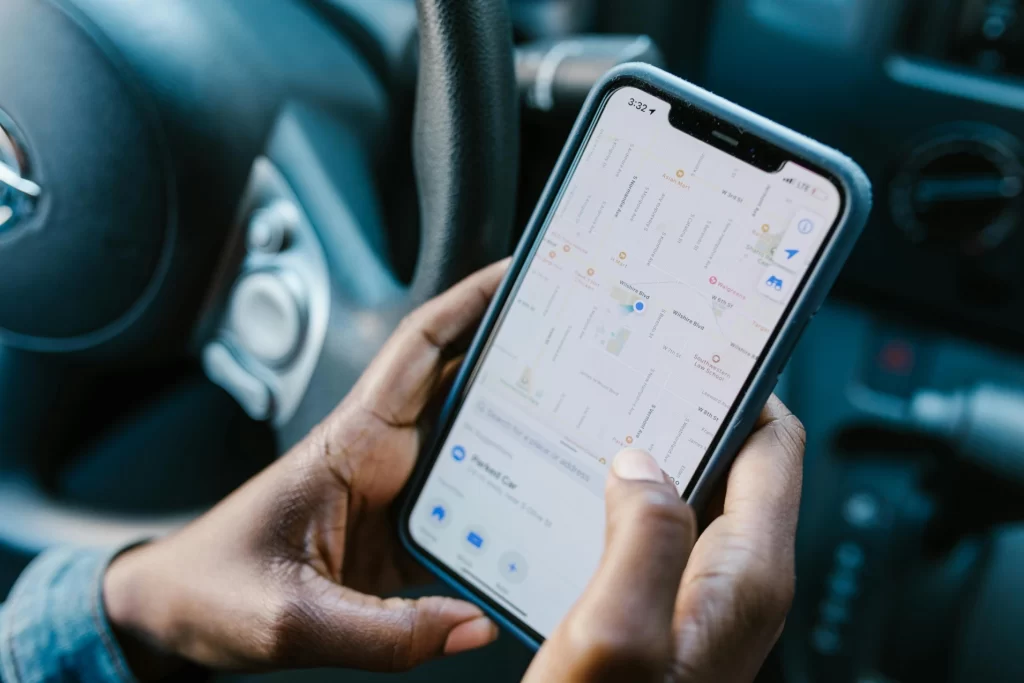 Driver using a smartphone GPS tracking app for navigation inside a car