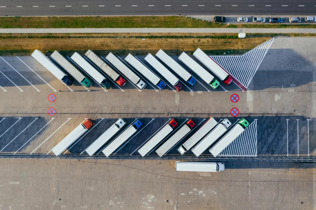 Aerial view of a commercial truck fleet parked in a lot, representing logistics, fleet management, and transportation efficiency.