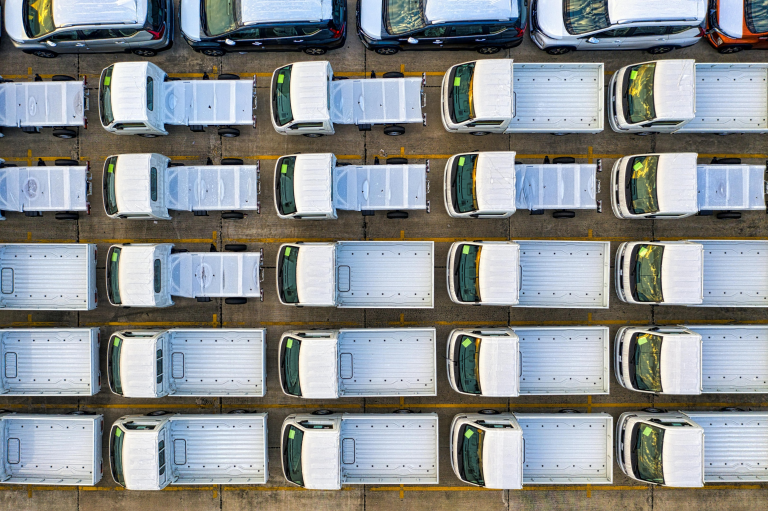 Aerial view of commercial fleet vehicles lined up in a parking area, representing fleet management and smart safety monitoring.