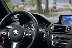 Driver’s view of a modern vehicle interior featuring a steering wheel, digital dashboard, and built-in navigation screen.