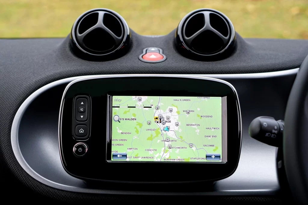 Close-up of a car dashboard with an integrated GPS navigation screen displaying a live map and route guidance.