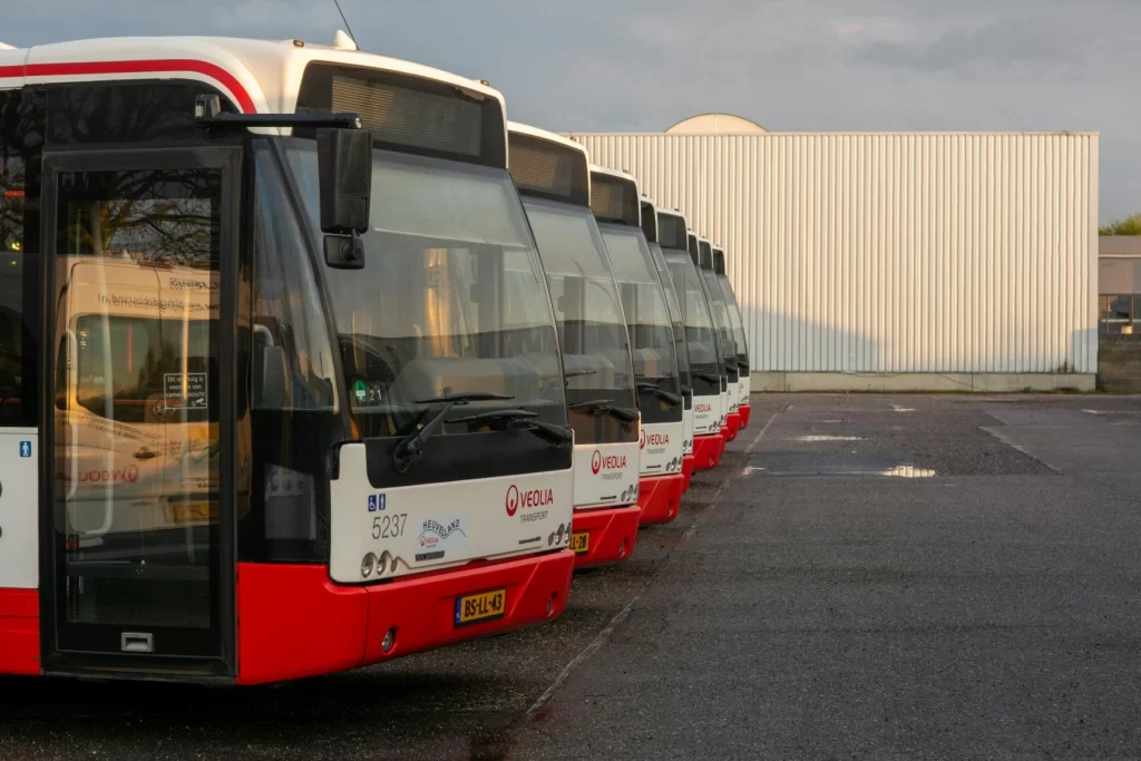 Commercial fleet buses parked in a row at a transport depot, showcasing fleet management and vehicle tracking operations.