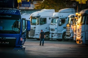 Truck driver walking through a commercial truck yard, highlighting fleet management, video telematics, and logistics operations.