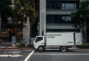 A delivery truck with "Good Stuff Inside" branding parked in a city, representing reliable delivery services that boost customer trust through real-time tracking.